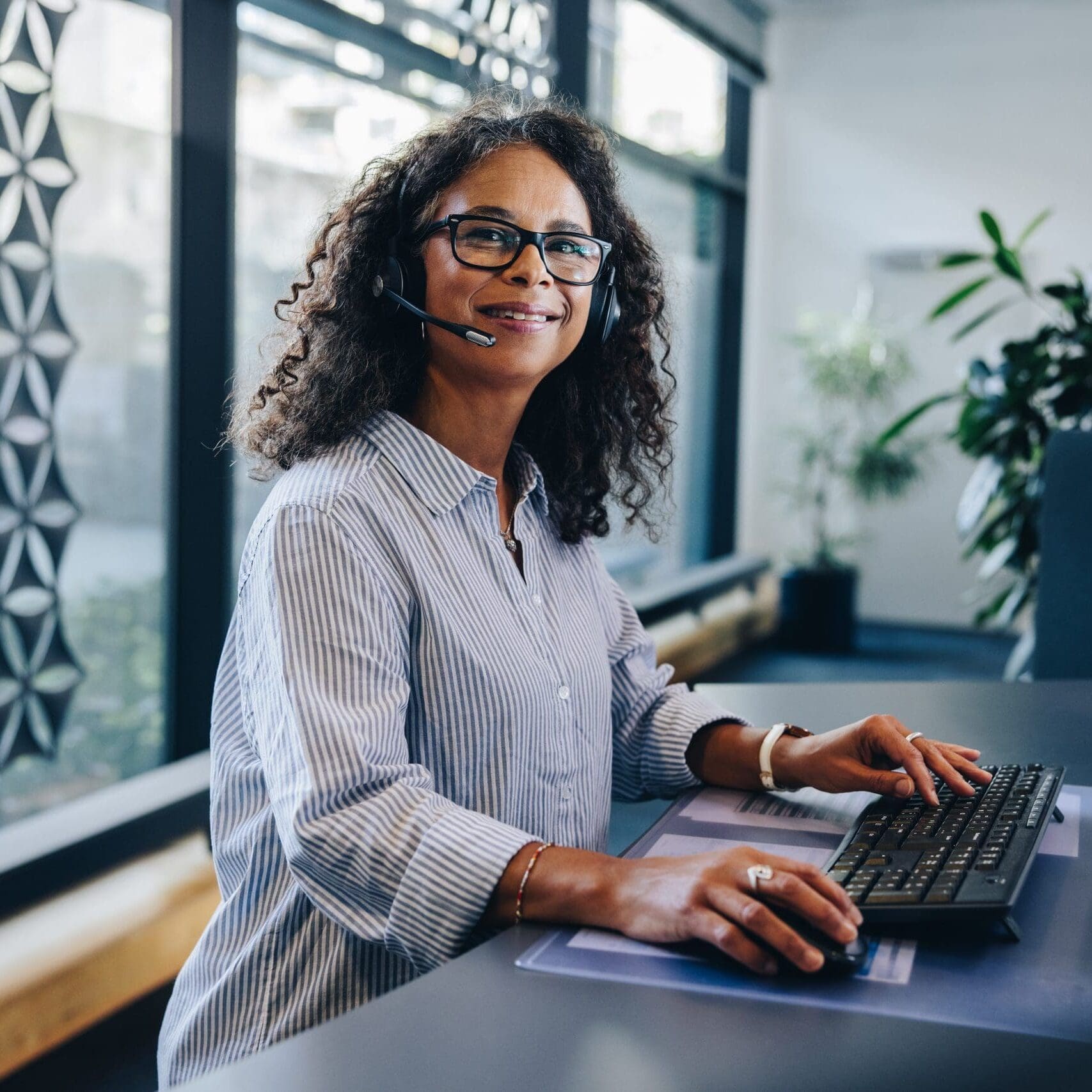 Portrait,Of,A,Mature,Businesswoman,Wearing,A,Headset,Sitting,At
