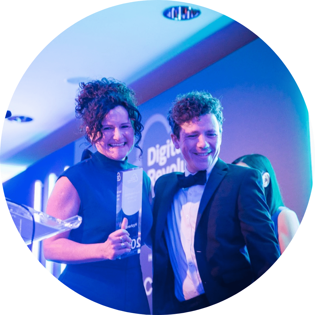 Joel and Elaine at Digital Rev awards Man and Women smiling leave stage with an award at the Digital Revolution awards.